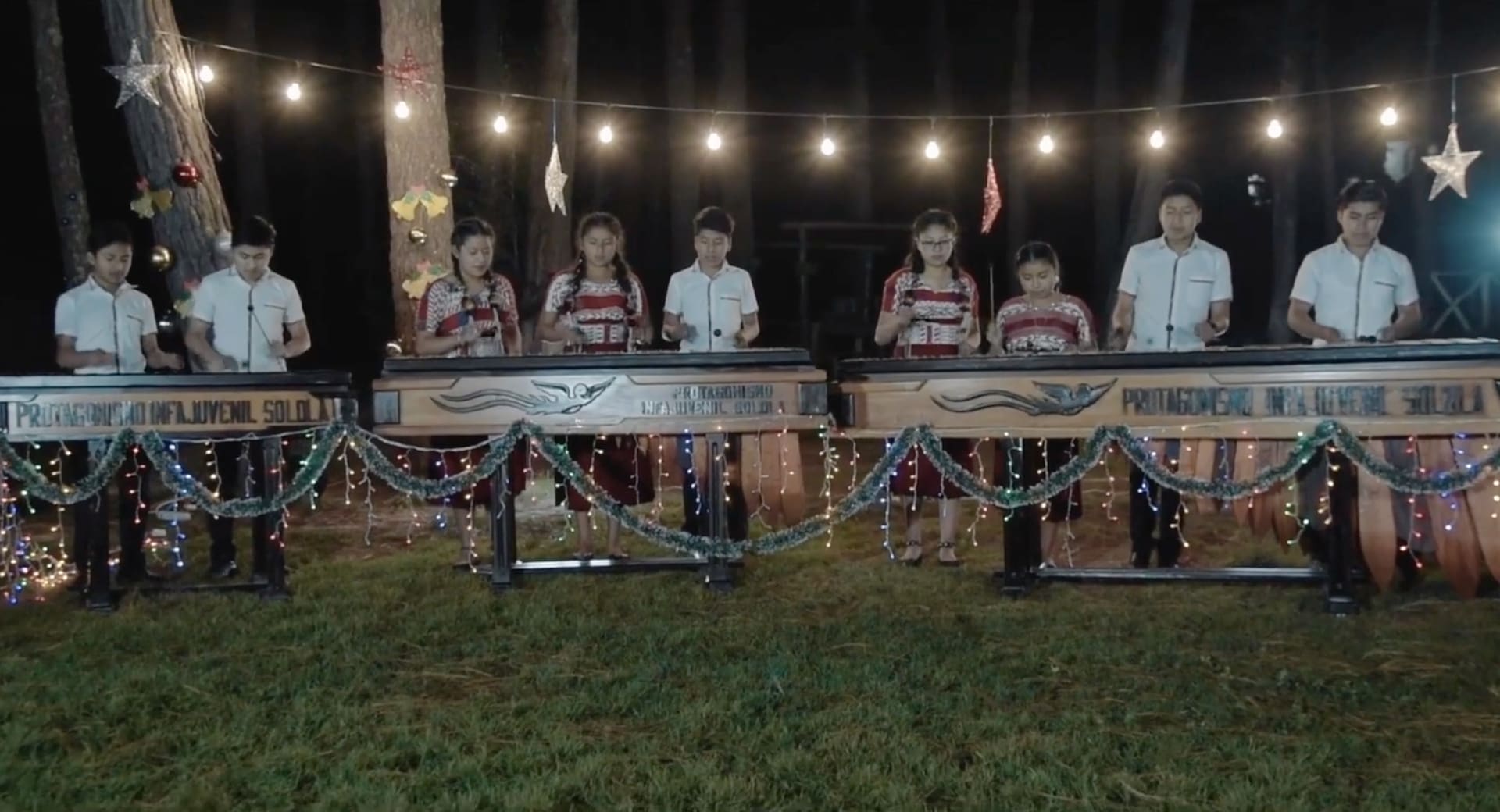 Dressed in traditional Indigenous clothing, Guatemalan kids play on the marimba.